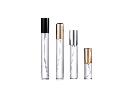Set of four clear perfume bottles with different colored caps on a white background